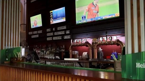 The bar with screens above and beer taps