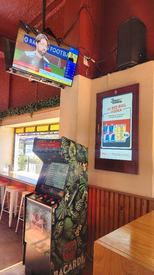 Inside the bar with a screen and arcade machine